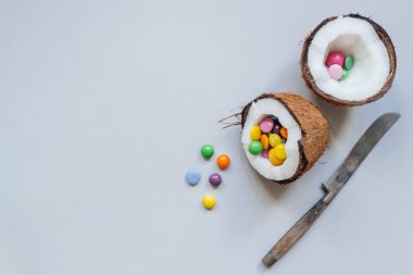 Olgun Hindistan cevizi ile renkli tatlılar gri arka planda, üstten görünüm