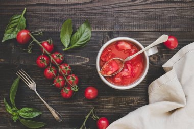 Tahta masada taze kiraz domates, fesleğen ve domates sosu, üst görünümü