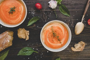 Ahşap masada ekmek ile domates krema çorbası, üst görünümü