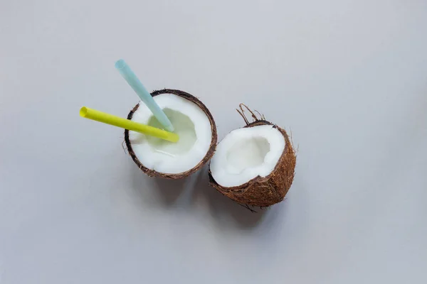 Rijpe kokosnoot met stro op de grijze achtergrond, bovenaanzicht, met kopie ruimte — Stockfoto