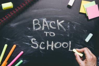 Okula geri yazma el. Kara tahta arka plan, eğitim kavramı üzerinde okul malzemeleri