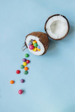 Olgun Hindistan cevizi ile mavi arka plan, üstten görünüm üzerinde renkli tatlılar