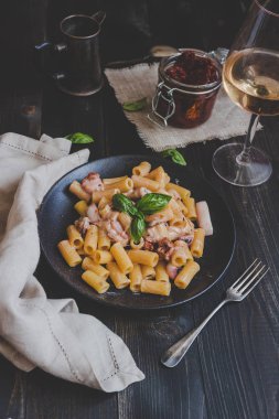 Rigatoni makarna ile deniz ürünleri ve fesleğen masada ahşap siyah, üstten görünüm