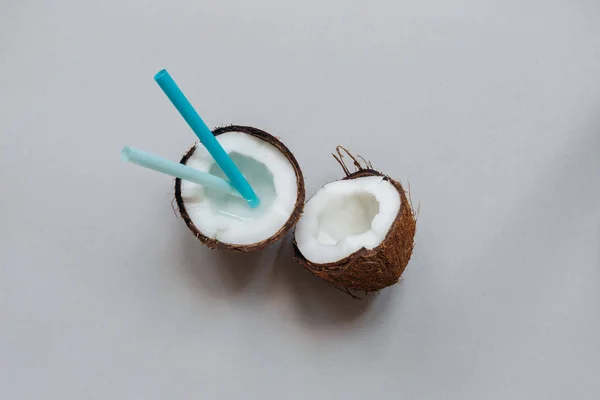 Rijpe kokosnoot met stro op de grijze achtergrond, bovenaanzicht, met kopie ruimte — Stockfoto