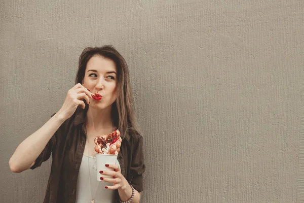 Jovem mulher comendo bolha waffle com frutas, chocolate e marshmallow, com espaço de cópia — Fotografia de Stock