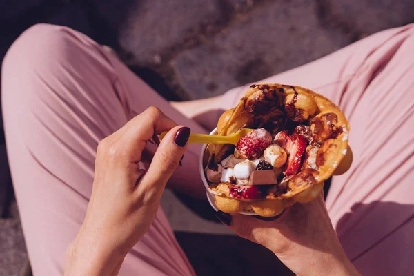 Junge Frau isst Blasenwaffel mit Früchten, Schokolade und Eibisch, von oben — Stockfoto