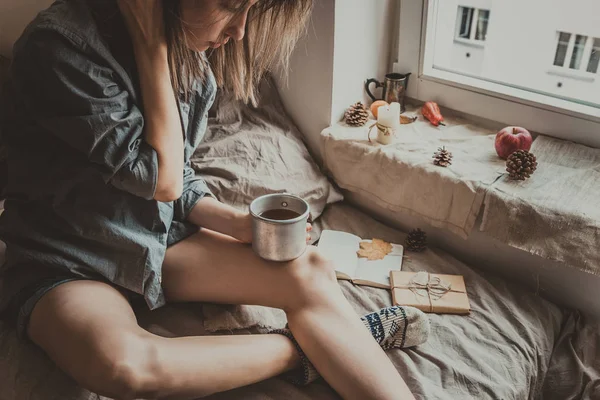 Confortable maison. Femme avec tasse de boisson chaude assise près de la fenêtre — Photo