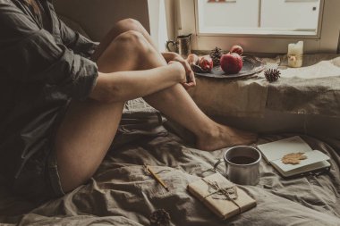 Rahat ev. Sıcak içecek cam kenarında oturan bir kadınla. Seçici odak