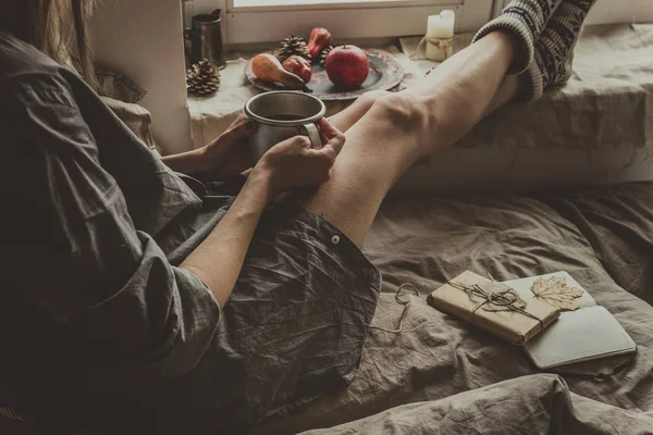 Confortable maison. Femme avec tasse de boisson chaude assise près de la fenêtre . — Photo