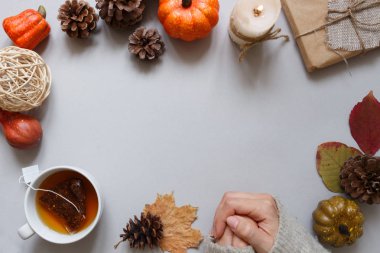 Sonbahar arka plan. Eller, çay, gri arka plan üzerinde sonbahar dekorasyon.