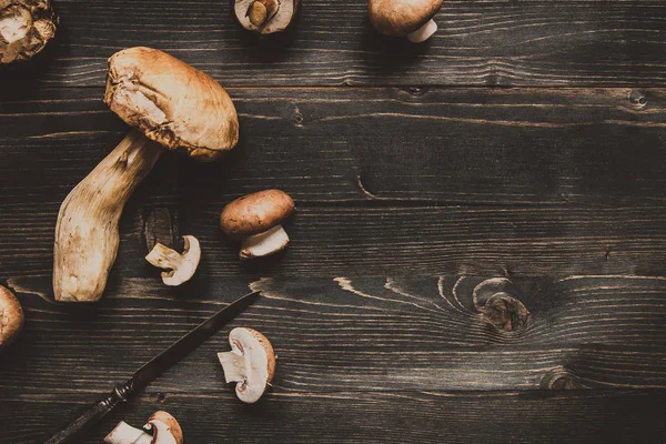 Taze kuruş topuz mantar masada ahşap siyah, üstten görünüm