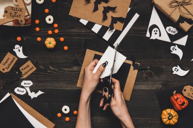 Cadılar Bayramı hazırlık. Cadılar Bayramı kartları ve Kraft kağıt kullanarak dekorasyon eller