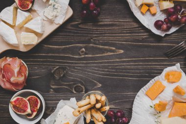 Meyve ve ahşap karanlık tablo kopya alanı ile snacks ile peynir seçimi. Üstten Görünüm arka plan