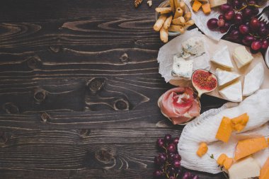 Çeşitli meyve ve ahşap karanlık tablo kopya alanı ile snacks ile peynir