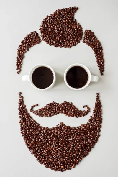 Homem hipster barbudo feito de grãos de café com copos feitos de xícaras de café — Fotografia de Stock