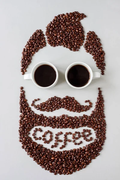 Conceito de café. Homem hipster barbudo feito de grãos de café com copos feitos de xícaras de café — Fotografia de Stock