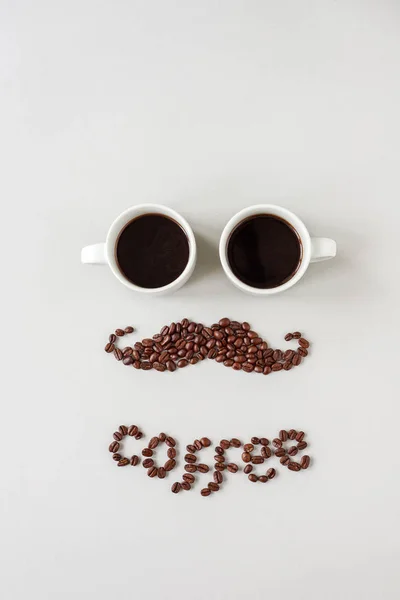 Mustache hecho de granos de café con vasos hechos de tazas de café — Foto de Stock