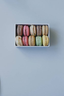 Şirin hediye kutusu ile hafif blu üzerinde lezzetli renkli macaroons