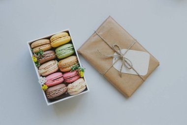 Şirin hediye kutusu ile hafif blu üzerinde lezzetli renkli macaroons
