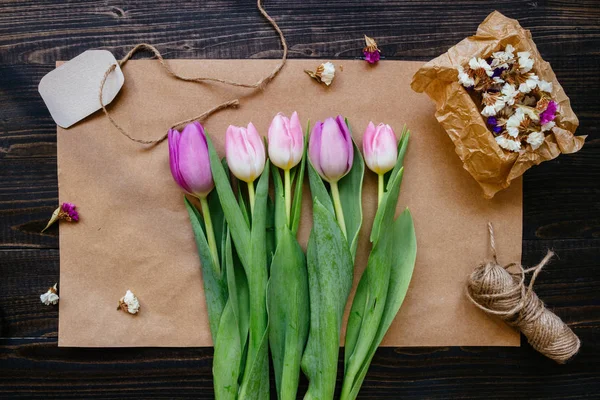 Ramo de hermosos tulipanes frescos con decoración en el fondo de madera — Foto de Stock