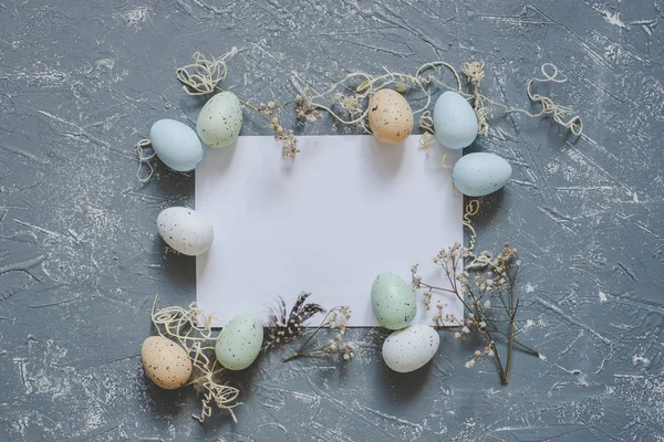 Vrolijk Pasen. Paaseieren met wit vel papier, top uitzicht. Kopiëren van ruimte — Stockfoto