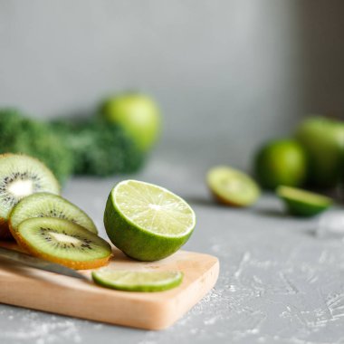 Olgun yeşil meyveler. Kireç ve kivi kesme tahtası üzerinde yakın.