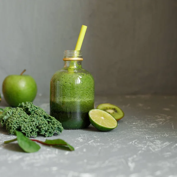 Batido verde saludable con col rizada, manzana, espinacas, lima y kiwi sobre fondo gris —  Fotos de Stock