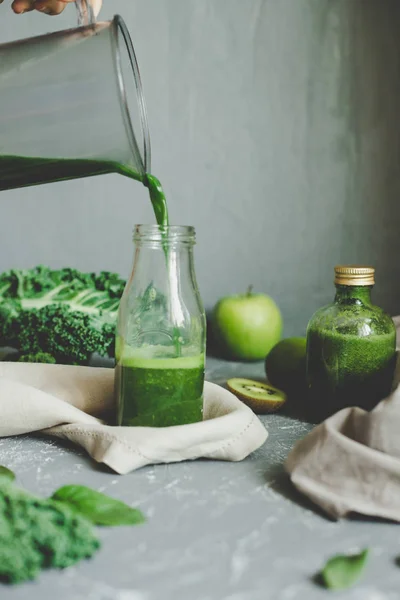 Manos vertiendo batido verde saludable en un frasco. Concepto de alimentación saludable —  Fotos de Stock