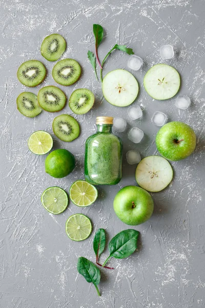 Smoothie vert sain avec des fruits verts frais et des feuilles d'épinards sur fond gris, vue de dessus — Photo
