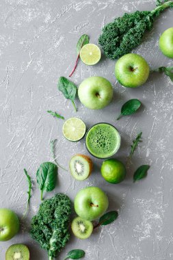 Taze yeşil meyveler, kale ve gri arka plan, üstten görünüm üzerinde ıspanak ile sağlıklı yeşil smoothie