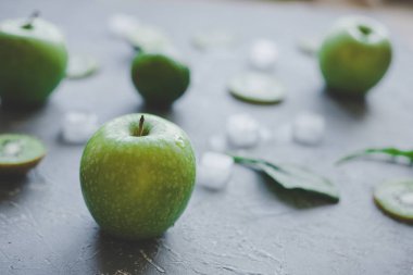 Rustik masada yeşil meyveler ve buz küpleri, seçici odak olgun yeşil elma