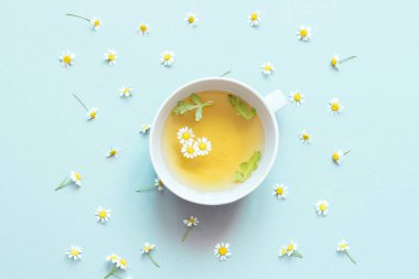 Bir fincan papatya çayı ve papatya çiçeği. 