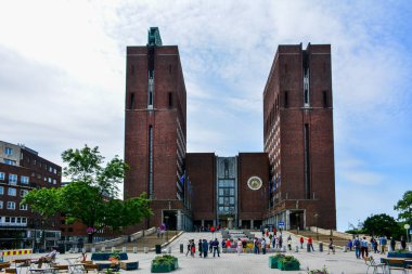 Oslo / Norveç - 23 Haziran 2019: İki kulesi ve astronomik saati olan Oslo Belediye Binası 'nın kuzey cephesi. Pipervika ilçesinde yer alan etkinlik, her yıl Nobel Barış Ödülü törenine ev sahipliği yapıyor.