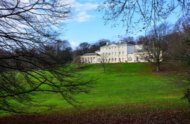Kenwood House, also known as Iveagh Bequest, on north end of Hampstead Heath, a large wild park in London, UK. The estate served as a private residence previously and houses a museum now clipart