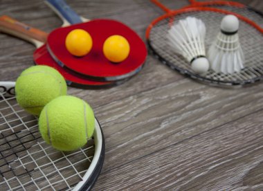 items for fitness racquets and accessories for badminton, table tennis and tennis on a wood background. clipart