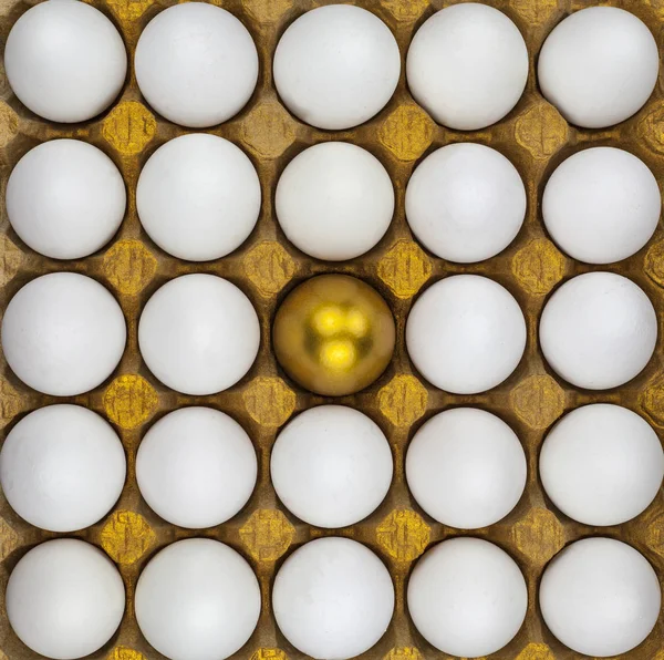 Chicken egg with a gold pattern surrounded by white eggs, Square background, texture.