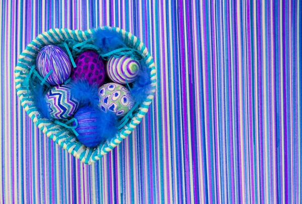 Easter background, spring flowers with easter eggs, Easter eggs decorated with a felt-tip pen, an ultra-violet striped background