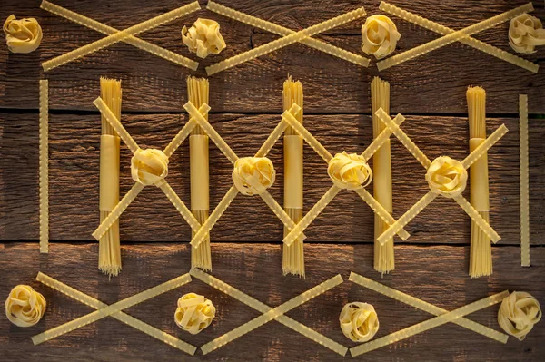 pasta placed with geometric signs on a wooden background