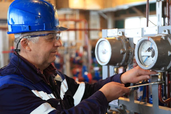 The mechanic - the repairman tightens bolts on a flanged connection of pipeline armature, operator production gas, locksmith repair instrumentation.
