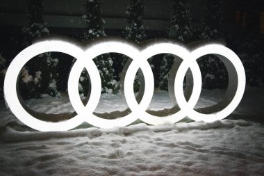 Krasnaya Polyana, Sochi, Rusya- 07 Aralık 2017: Aydınlatmalı Audi'nin şirket logosu, yeni yıl ağacının arka planında, akşam, kar yağıyor, gürültülü fotoğraf.