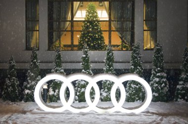 Krasnaya Polyana, Sochi, Rusya- 07 Aralık 2017: Aydınlatmalı Audi'nin şirket logosu, yeni yıl ağacının arka planında, akşam, kar yağıyor, gürültülü fotoğraf.