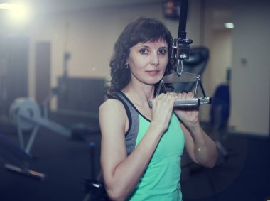 Fitness egzersizleri, bir kadın bir egzersiz bar tezgah basın omuzlarında gerçekleştirir
