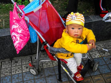 Chengdu, Çin - 24 Nisan 2017: Chengdu şehir sokak, Çinli çocuk arabasındaki bebek        