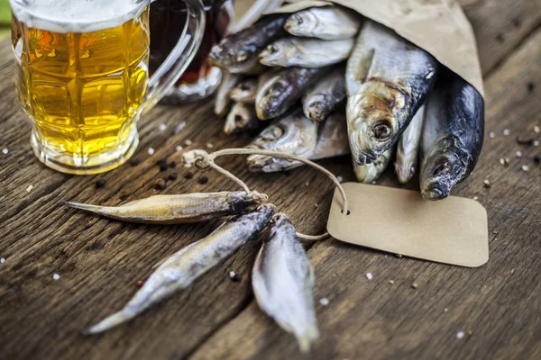 Pescado seco sobre fondo de madera con cerveza —  Fotos de Stock