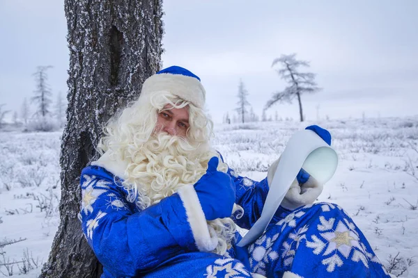 Boldog Mikulás egy havas erdőben, Mikulás a háttérben — Stock Fotó