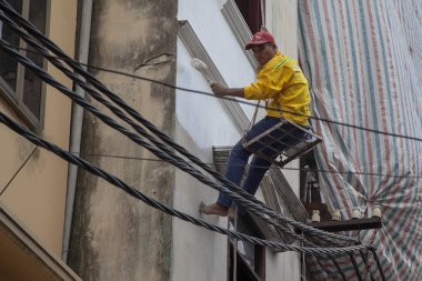 Vietnamlı işçiler duvar boyuyor, inşaatçılar birlikte duvar boyuyor.