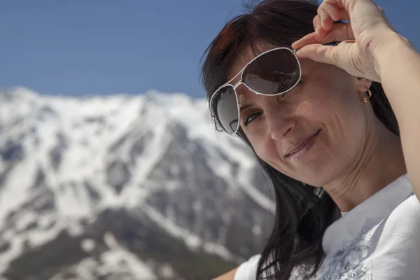 woman in winter shows class on the background of a ski slope