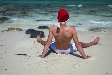 Noel kartı, Noel Baba şapkalı adam güzel bir sahilde