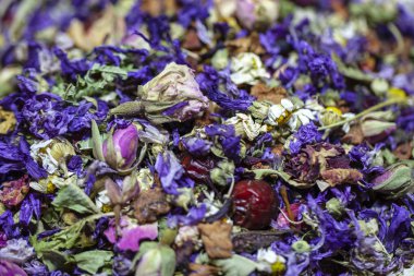 Çiçekli siyah çayın arka planı, gül yapraklarıyla, siyah çayla