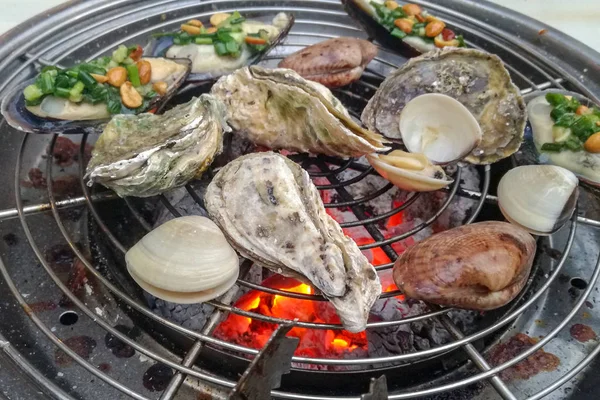 Mořské jídlo, mořské plody na grilu, krevety, ústřice, žába — Stock fotografie